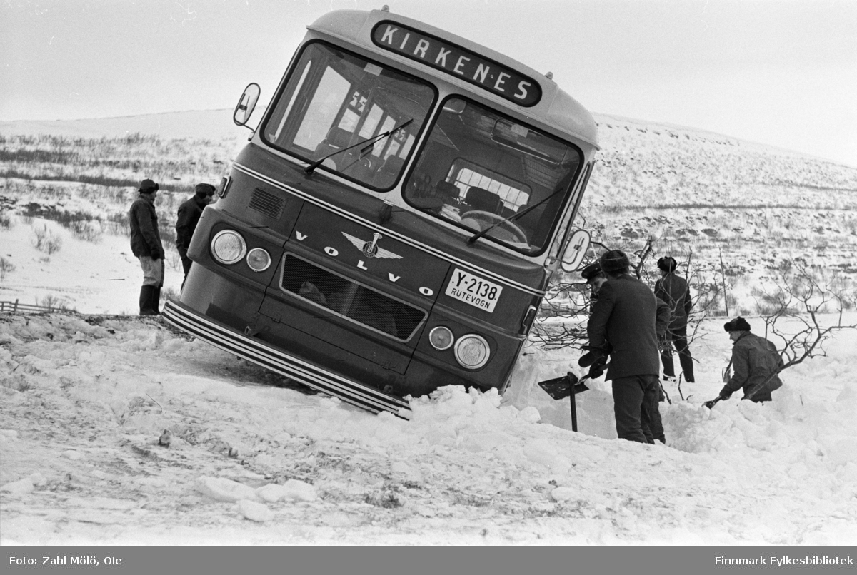 Busshavari i Paddeby, like vest for elva.  Bildet er tatt  ca. 15.2.1967. Buss med registreringsnummer Y-2138 var en Volvo B715, 1966-modell, 44 seter, med karosseri fra Larvik Karosserifabrikk. Fabrikkens logo (vingehjul) ses midt i fronter, over "Volvo". Bussen tilhørte busselskapet Polarbil, Vadsø, som hadde rutetrafikken i Øst-Finnmark fra 1920 til selskapet ble overtatt av Finnmark Fylkesrederi og Ruteselskap (FFR) 1. januar 1976.