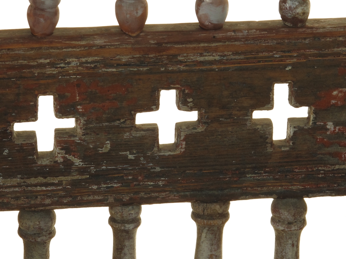 Senmiddelaldersk type, av dreiede pinner. Muligens opprinnelig kirkestol, da der er rader med kors i ryggen. Armlenene har på undersiden festet 6 små  balustre, som nedentil er festet i nok en dreiet tverrligger. Der har likeledes vært balustre (3 stk) under sargen i fronten ned til den øvre tverrstreber. Ryggen består av avvekslende dreiede balustre i tett  rad og horisontale bretter med utskårne gjennombrutte kors. Buet toppstykke. Endene av bakstavene har dreide knotter.