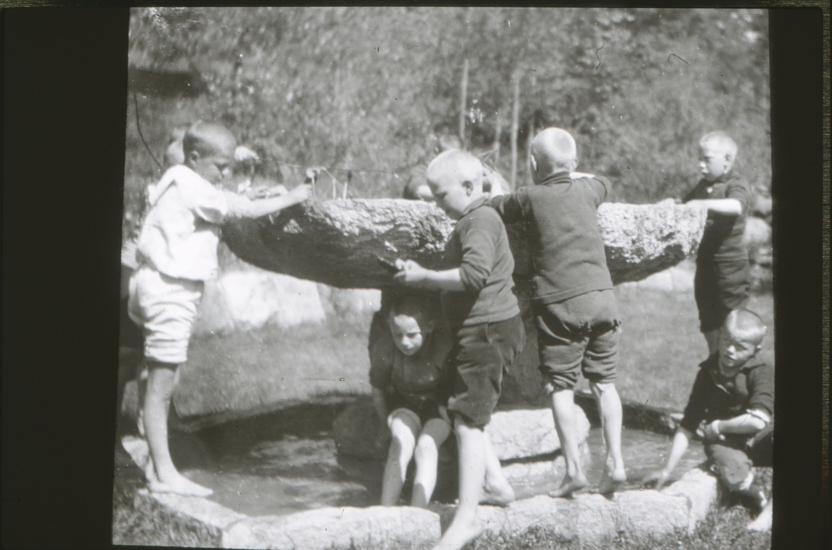Gutter fra friluftsskolen Vangen leker i fontenen i hagen på Asker Museum.
