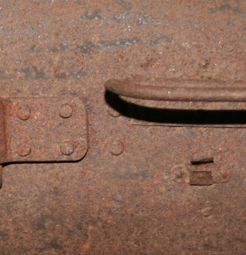 Kontainer. Laget av valsede jernplater, klinket sammen. I to halvdeler, med lukkemekanisme.