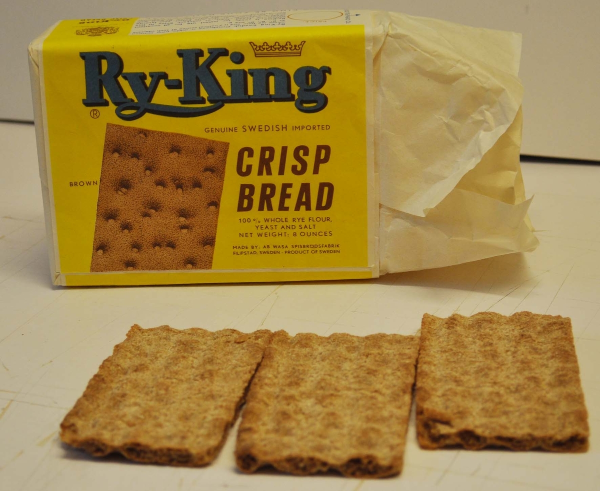 3 skivor knäckebröd i förpackning märkt "Ry-King" i blått på gul botten. Fotobild på ett knäckebröd. Text på engelska "CRISP BREAD"