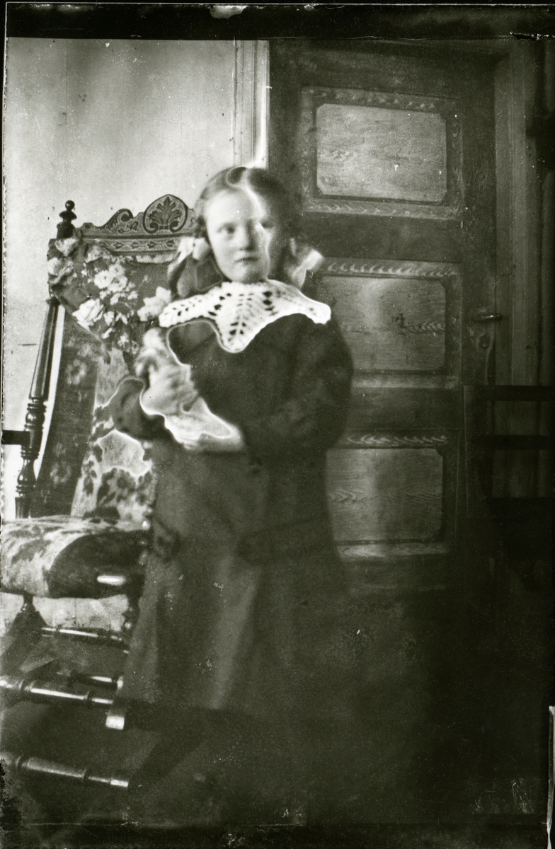 Jente ved gyngestol, ca 1910-1915.