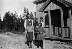 Familie utafor nybygd hus