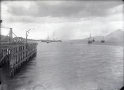 Brygge med fartøyer i bakgrunnen