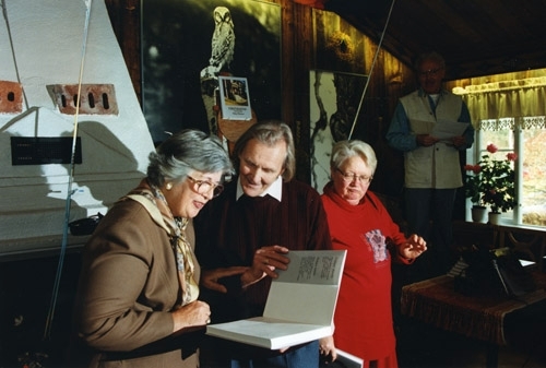 Fotografiet är taget i samband med utgivningen av boken "Förstukvistar i Hälsingland". Hilding och två kvinnor tittar i hans bok.