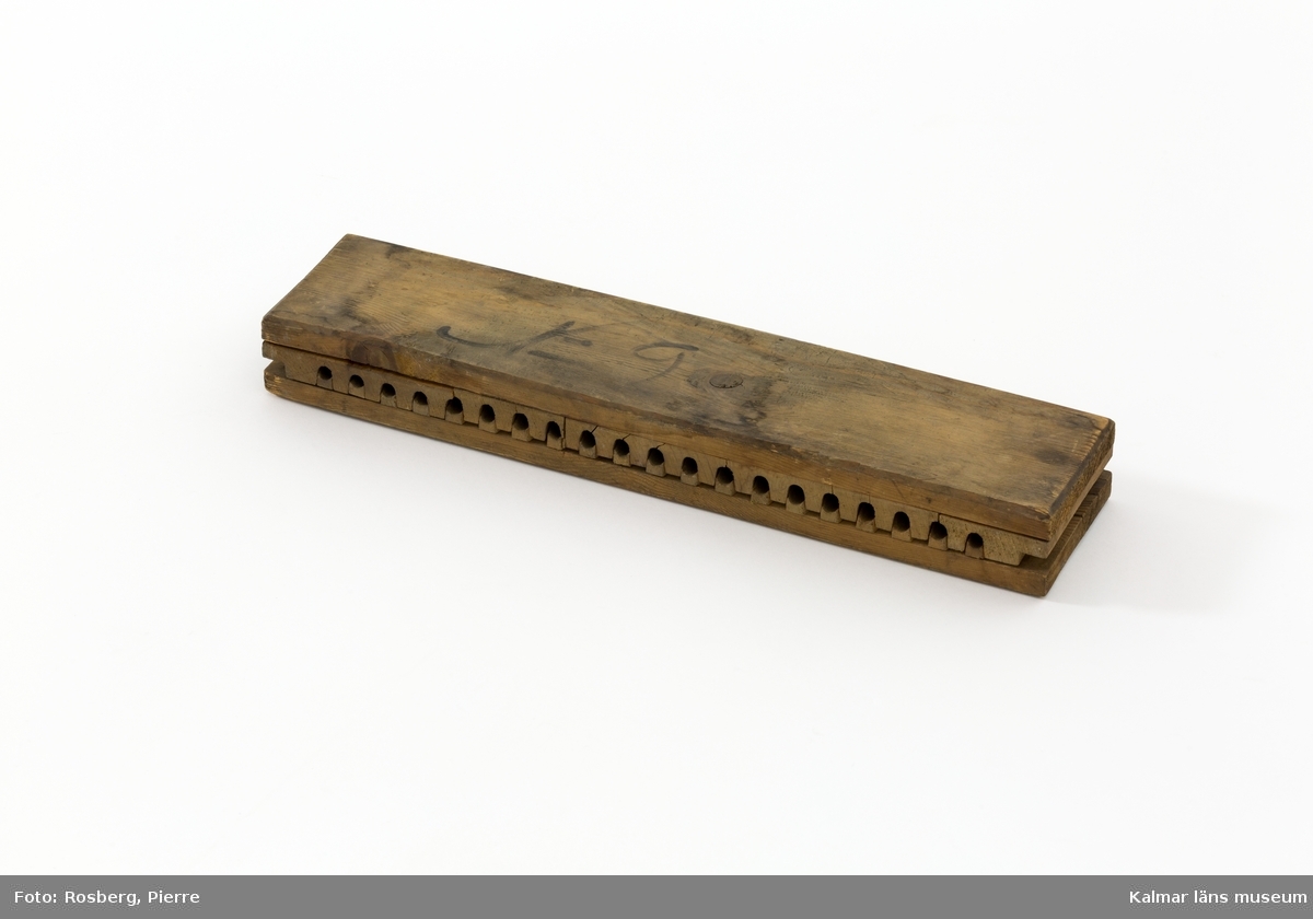 KLM 20584:1. Cigarrform. Form för tillverkning av cigarrer. Av trä. Rektangulär form för 20 stycken, 11,5 cm långa, cigarrer. På ovansidan otydlig text i svart, troligen N 9.