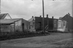 I midten er boligbrakke med tre leiligheter i første og en l