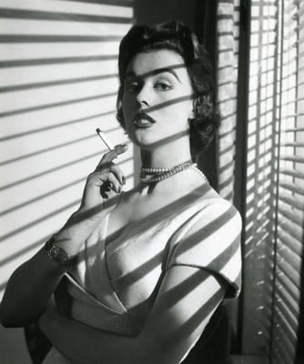 Kvinne ved vindu med sigarett i hånden.. Foto/Photo