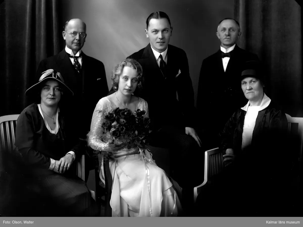 Ateljébild i bröllopssammanhang. Bruden, brudgummen och bröllopsvittnen finns på plats. Enligt Walter Olsons journal är bilden beställd av herr Gösta Rosenlund.