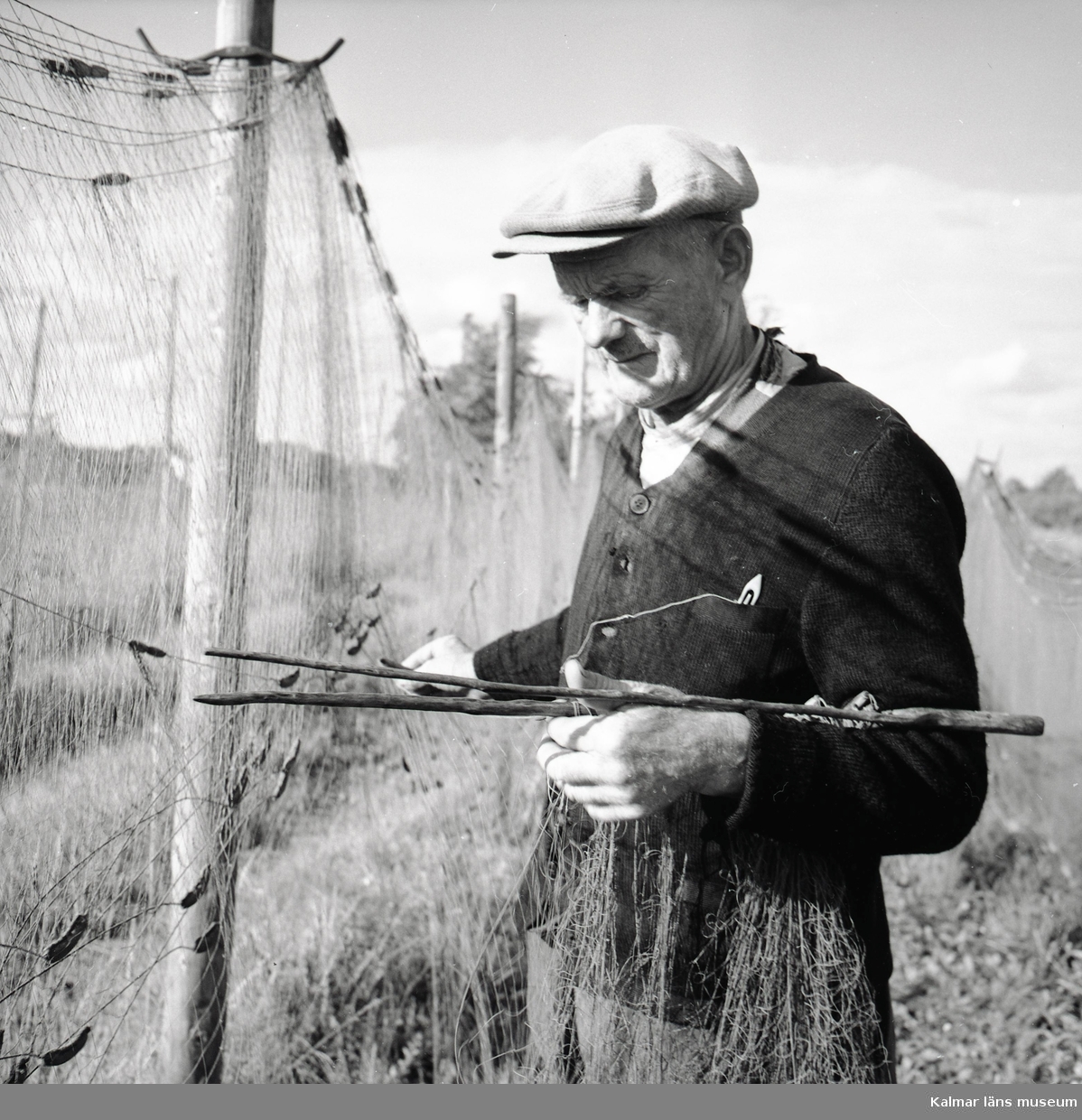 Karl Johansson arbetar med fiskenät vid Stensö fiskeläge.