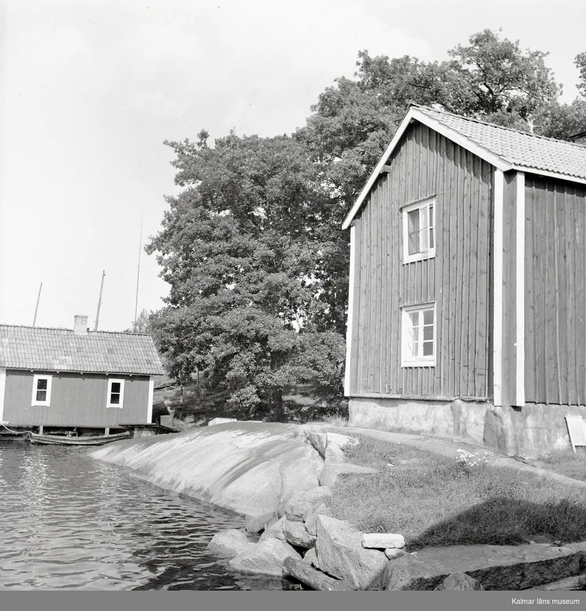 Hus och sjöbod i bakgrunden på Älö.
