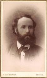 portrettfotografi av mann med heilskjegg, mørk jakke/vest og