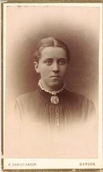 portrettfotografi av kvinne med midtskill, kledd i mørk kjol