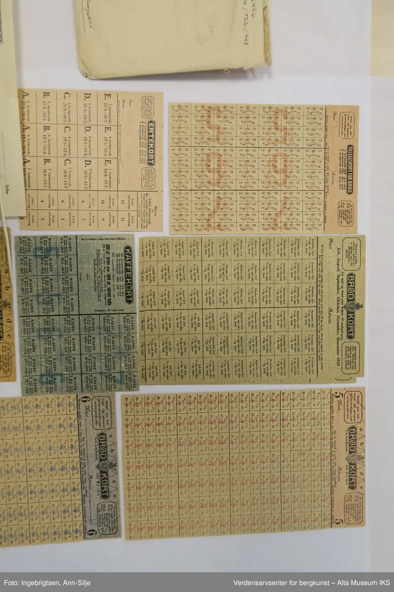 Konvolutt med mange rasjoneringskort. Det er kort for blant annet brød, erter, kaffe og sukker.