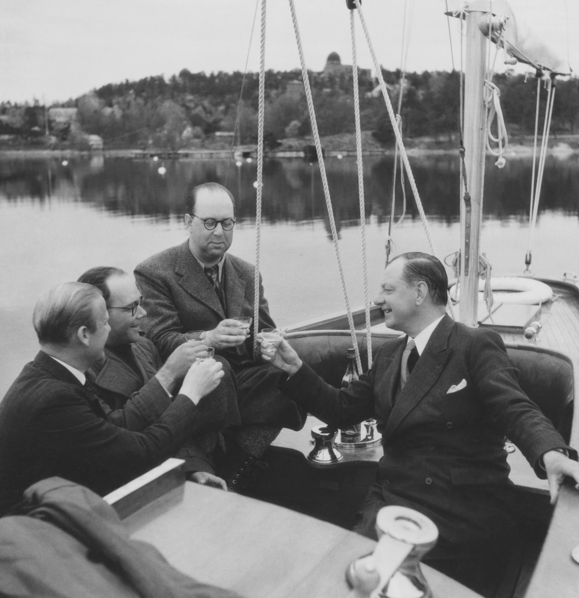 Gösta Åhlén tredje personen från vänster, Roy Hähnel längst till höger i segelbåt med en flaska konjak.