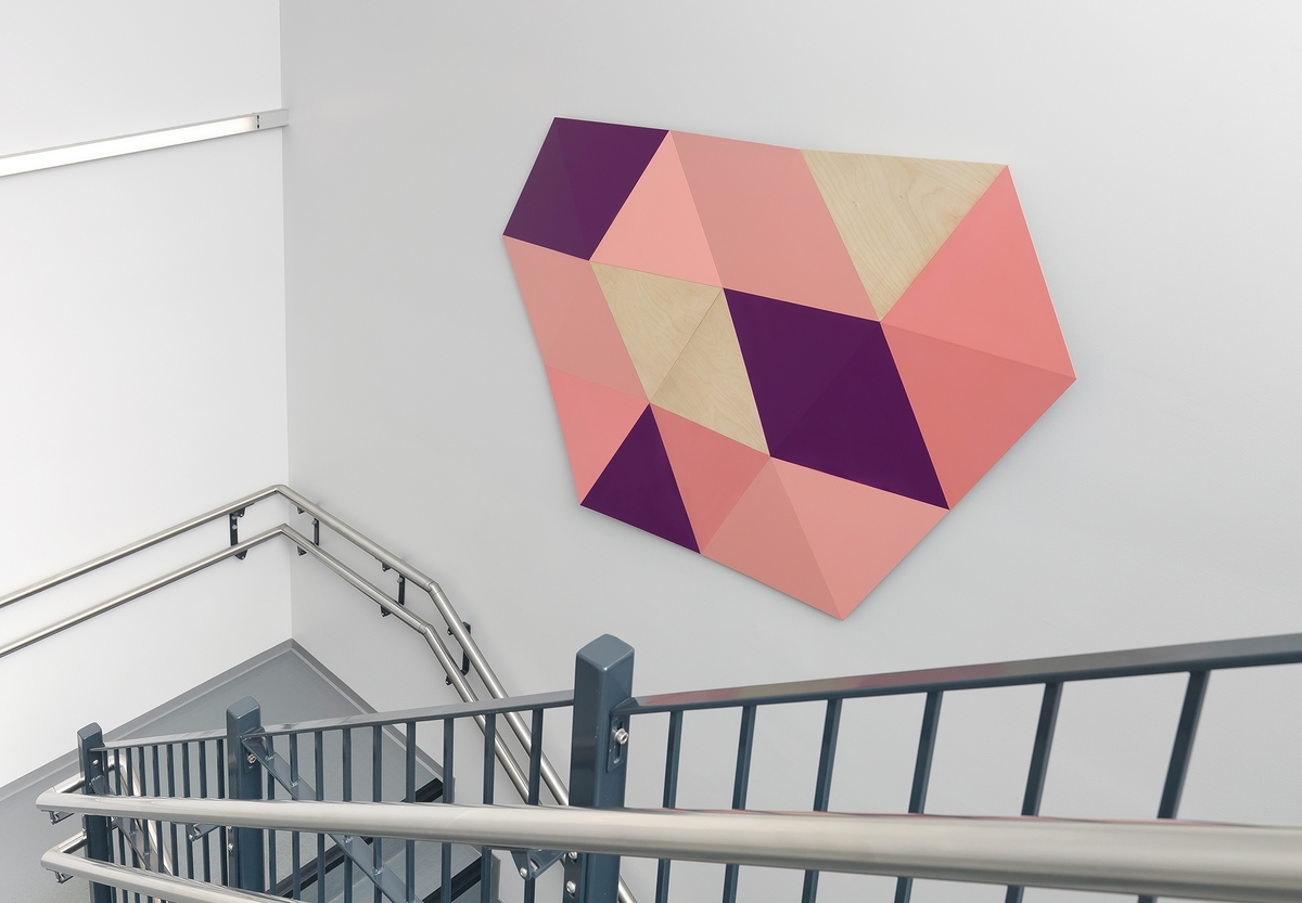 Lieksidete trekanter og romber danner til sammen et abstrakt mønster med ulik gradering mot veggen.