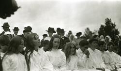 Jenter og gutter, kvinner og menn, sittende i rekke og rad m