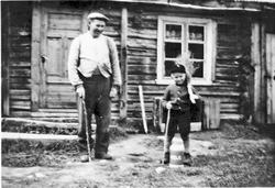 Mann og gutt, klær, melkespann, bolighus.