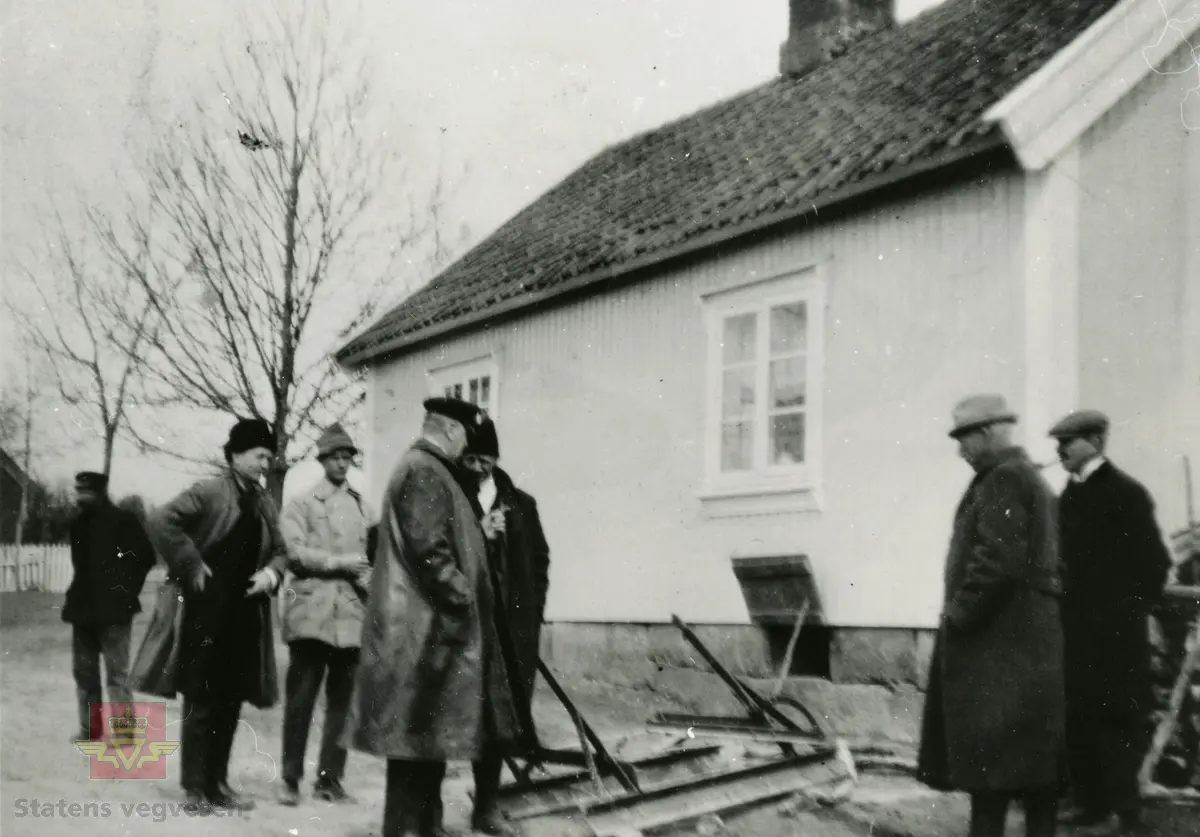 Amerikansk veghøvel "Russel Grader"  i arbeid i Østfold 1924, i følge merking.  Ref. til "Meddelelser fra Veidirektøren", Nr. 47-mai 1924. Artikkel om "Prøve med den amerikanske veihøvel "Russel Grader" samt skrapning av veibanen med "Western" skrape", av overingeniør Thor Olsen. Befaring  med vegdirektoratets og Østfold fylkets ingeniører.  Andre bilder av veghøvelen som er illustrert i artikkelen vises i bildeframvisning 2/5 og 3/5. Bildeframvisning 4/5: "Skraperne av "Western"-typen forarbeides som nævnt ved fylkets verksted og utstyres nu med en fast arm paa den ene side for styring av hele redskapen foruten den bevægelige for stillingen av bladene , som det vil sees av fig. 5". Bildeframvisning 5/5: Vedlikeholdsarbeid med amerikansk vegskrape utføres i Østfold.