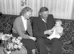 Et eldre par med en baby på fanget, kanskje er det bestefore