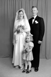 Foto av et brudepar, trolig med datter. Familien er sannsynl