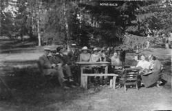 Personer, bord, benk og stol, naturforhold.