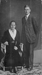 Personer (to), klær, stol.