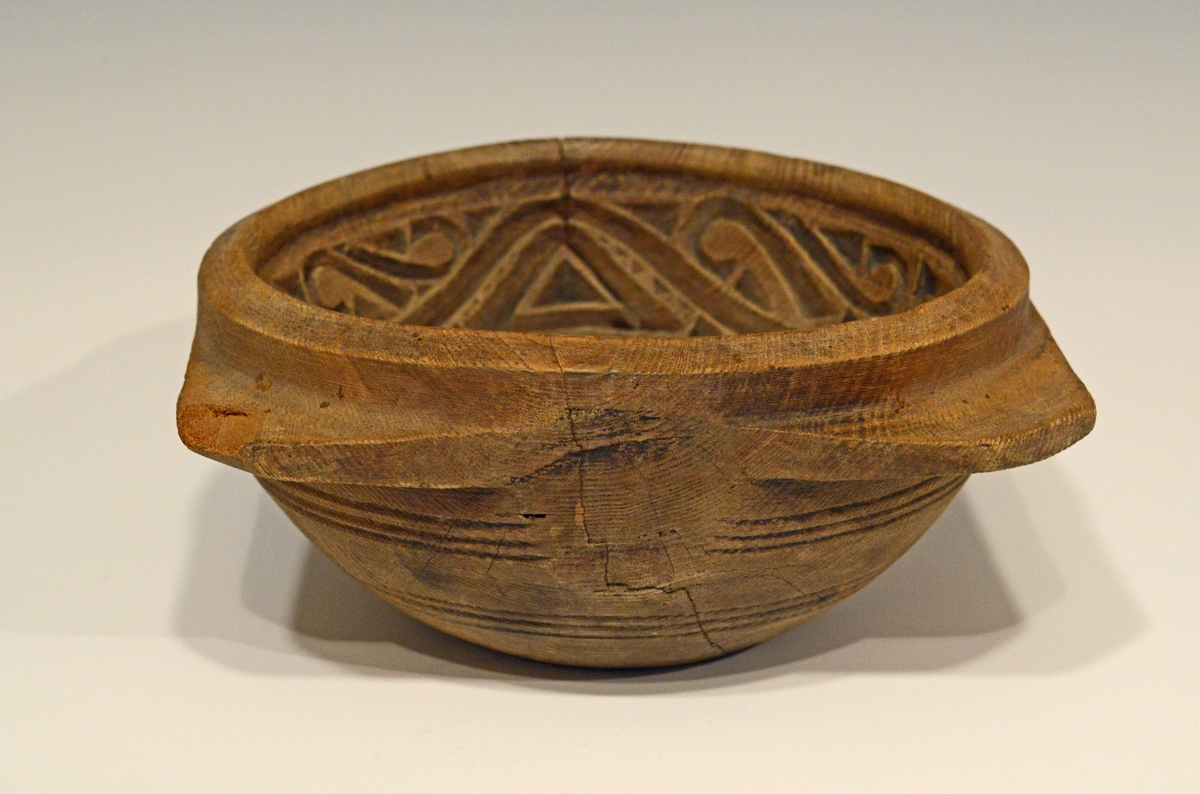 Fra protokollen: 
Rund, halvkugleformig. 4 ører som haandtak.
Smørformen har et lite hull i midten og det ene hjørnet mangler en del.