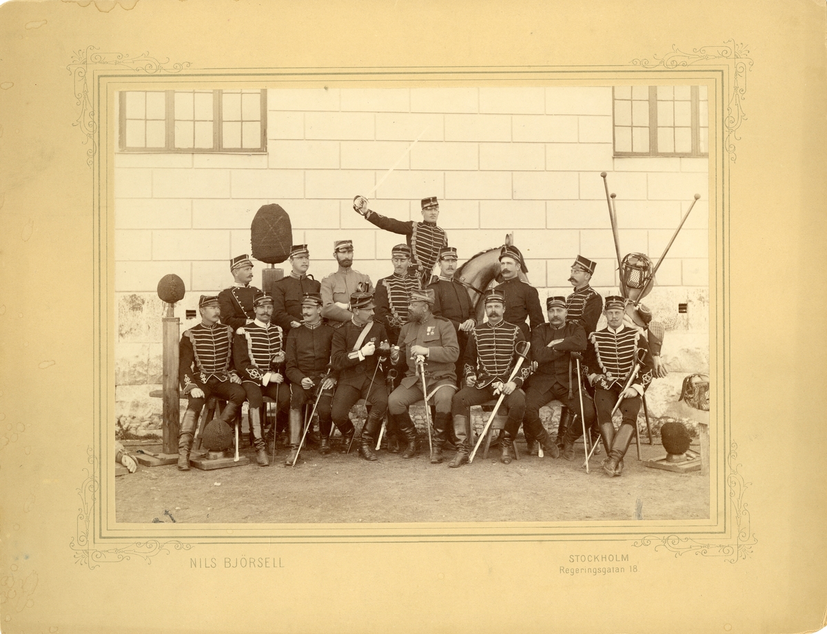 Officerssällskap bestående av husarer, dragoner, infanterister och artillerister poserar framför K2:s förläggning på Ladugårdsgärde under sabelfäktningskurs 1890.