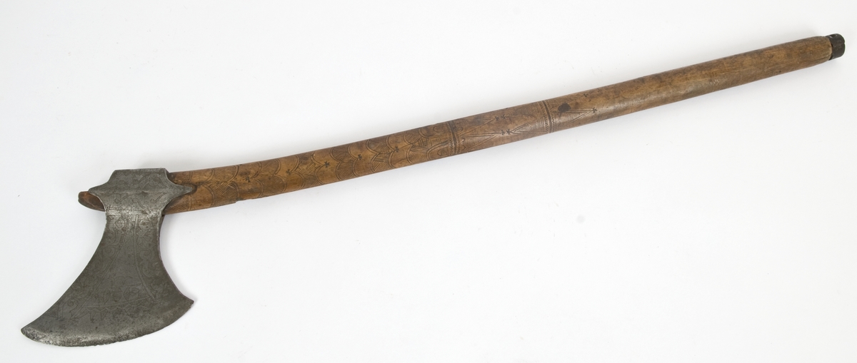Asymmetrisk blad med lang øvre spiss og kortere nedre spiss.
Bladet er tynt, med påsmidd noe tykkere egg.
Øksehammeren har skaftehull og fliker.
Smedmerke formet som et skjell. Øksen har etset rankedekor på begge sider.
Skaftet er svakt krummet. Skaftet er merket på ryggen S 1683 .Skaftet har skåret dekor i felter. Skaftet har jernring nede.