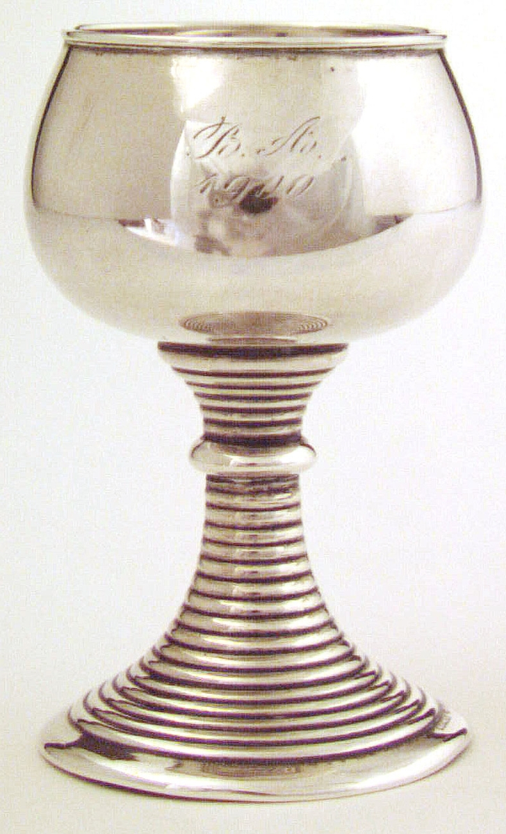 Prispokal av silver på fot. Graverat på framsidan: BA 1900. (Birger Andrén). Stämplad Hallberg V6 1899.