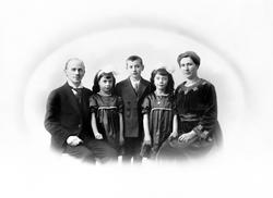 Gruppeportrett av ukjent sittende mann og kvinne med tvillin