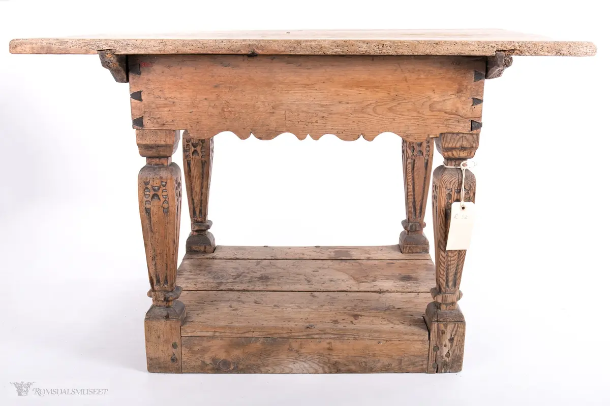 Platen hviler på arkitrav som igjen hviler på koniske pillarer med en form for kannelering med kapitel/terningkapitel og basis. Alt hviler på postamentet med høyde 12 cm.