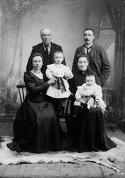 Familieportrett, to små barn i fanget på to damer. To menn, 