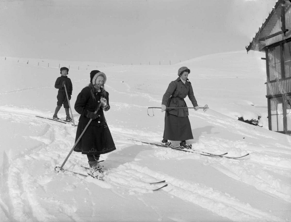 Hjerkinn fjellstue på Dovrefjell. Lærerinne frøken Askvik og  Ragnhild og Johan Hjerkinn på ski.