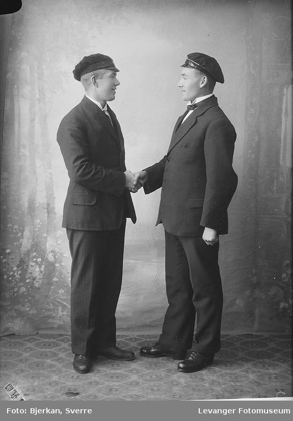 Portrett av to menn  som gratulerer hverandre med studenten  merket J. Selnes.