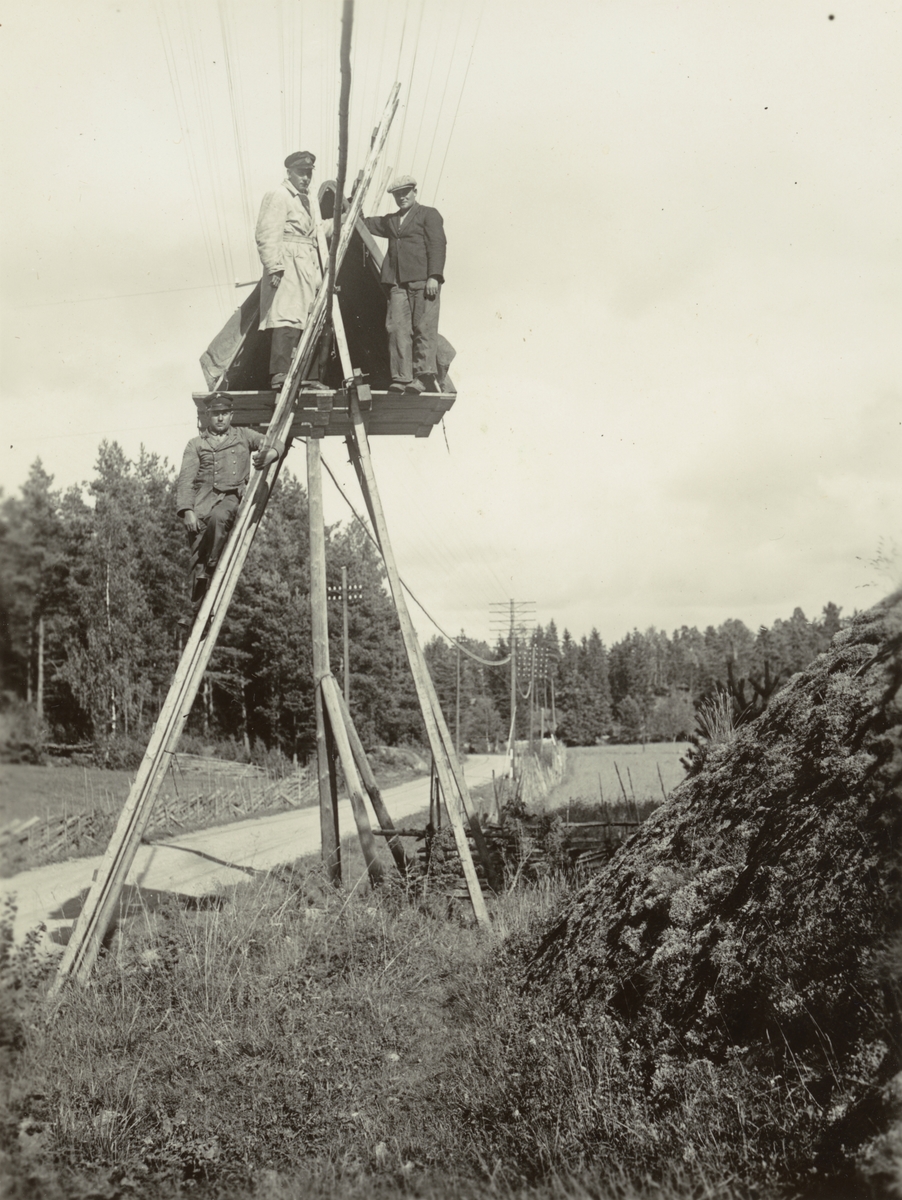 Män i arbete.
Första skarvarna vid Hjälmsätra. C 26. 
Ur album Kabelarbetet Hjälmsälra - Norrtälje - Finnviken utfört under sommaren 1928.
