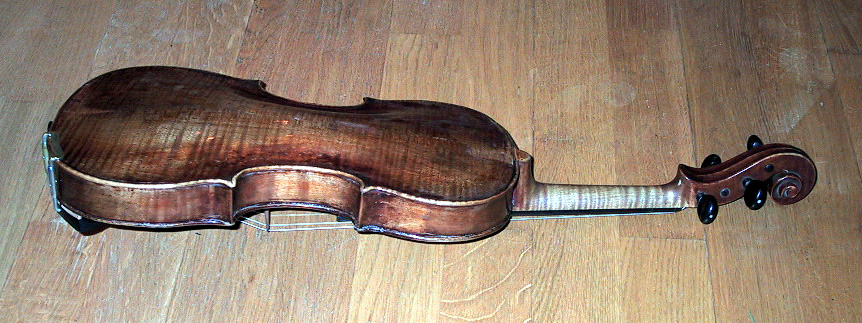 Fiolinkasse (a), folin (b) og bue (c). Kassen er i lær. Åpning i begge ender. Hemmelig rom i toppen. Preget dekor i læret. Kassa har lås. Fiolinen er god, kassen er slitt