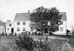 Ukjent gårdsbruk, våningshus og stabbur med familien og hest