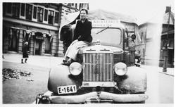 Ung dame sitter på panseret til en lastebil.