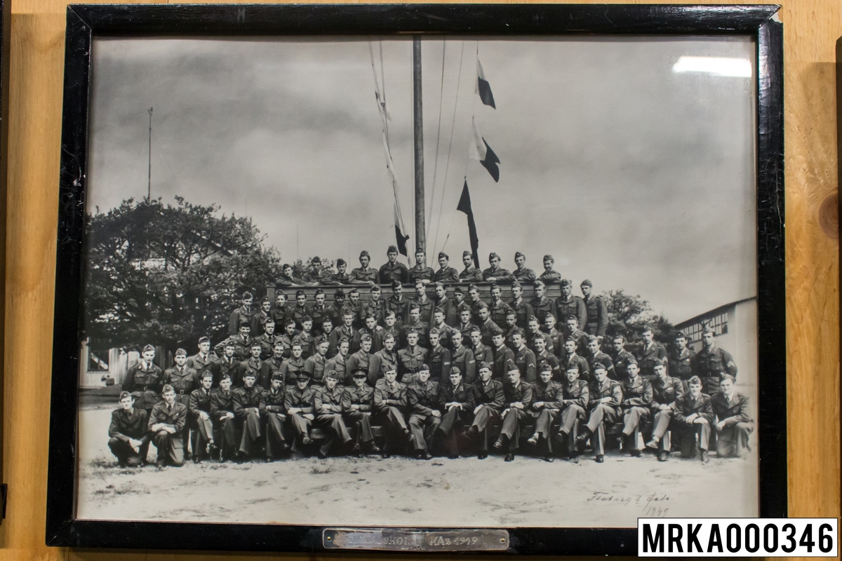 Fotografi taget på befäl och soldater som genomfört grundläggande soldatutbildning på 1:a Batteriet KA 2.
Fotografiet taget på övre plan KA 2.
Flobergs Foto 1949.