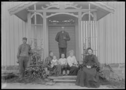 Ukjent familie foran hus.