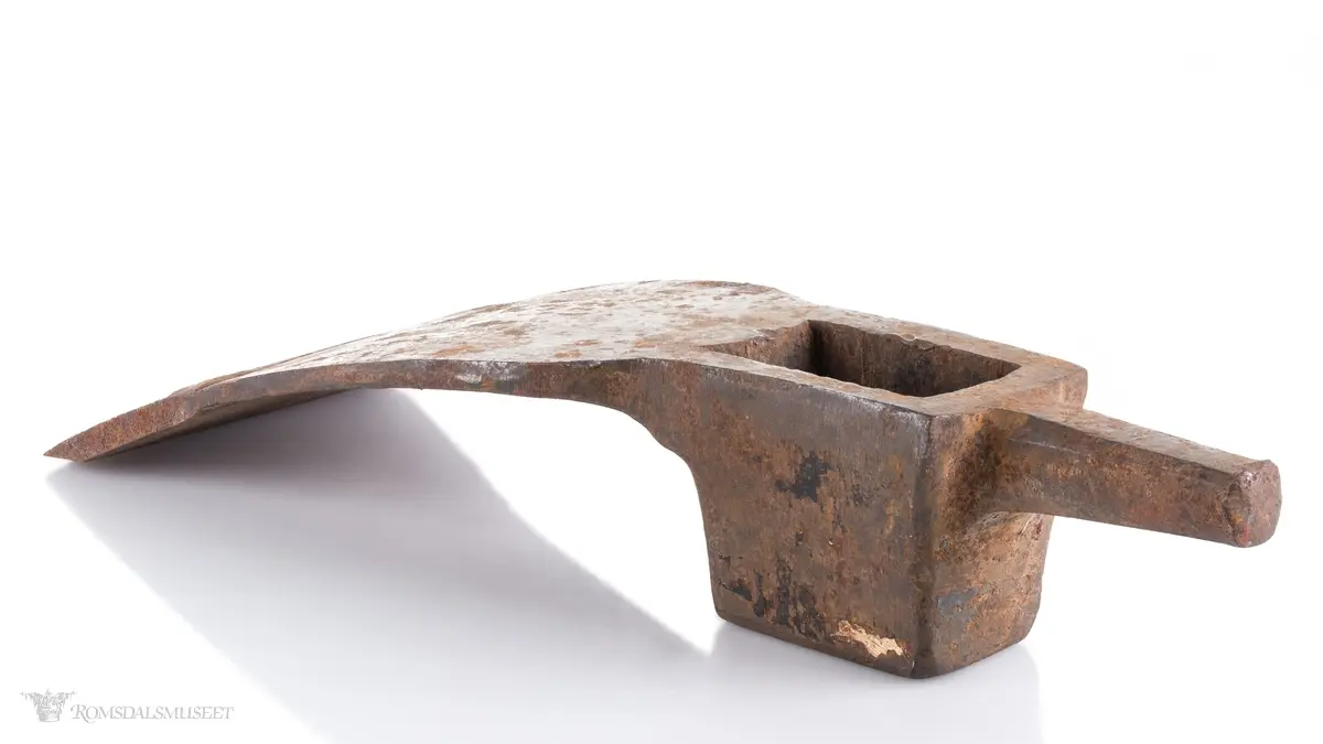Øksehode med eggen på tvers i forhold til skaftefestet. Rett egg som ser ut til å ha blitt smidd på av bruker. Hammer med firkantet snitt i bakkant av hodet som smalner av mot enden. En tverrøks brukes til å hugge stokker og planker for å jevne ut flater, forme bjelker og takrygger samt ved snekring og båtbygging.