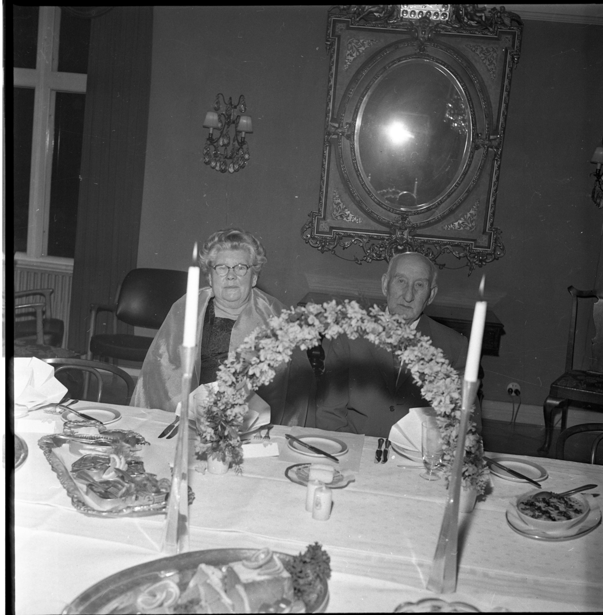 Middag på Ribbagården (?) i Gränna. Man firar Herman och Edit Thörns guldbröllop, samtidigt Anna-Greta Fransson 40 år och Vivan Strand 50 år. Bakom blomsterbågen sitter Edit och Herman Thörn.