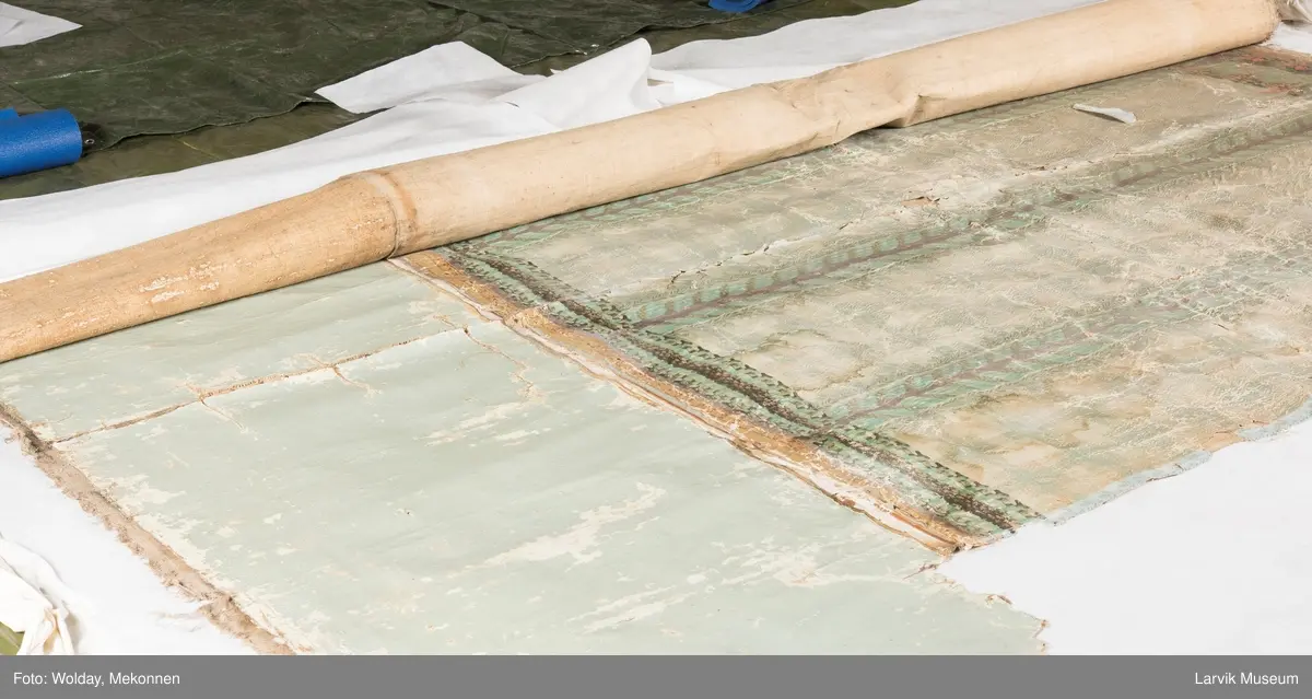 |Tapeten er påmalt tapetborder og brystning. Fra Hovland gård i Larvik.
Den øverste, brede borden: Gerlander/draperi med blomsterranker.
Den nederste, smalere borden: Tekstilbord med blomster. Øver døren til høyre: Stillebenmotiv med blomster og frukt.