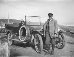 Mann står foran bil