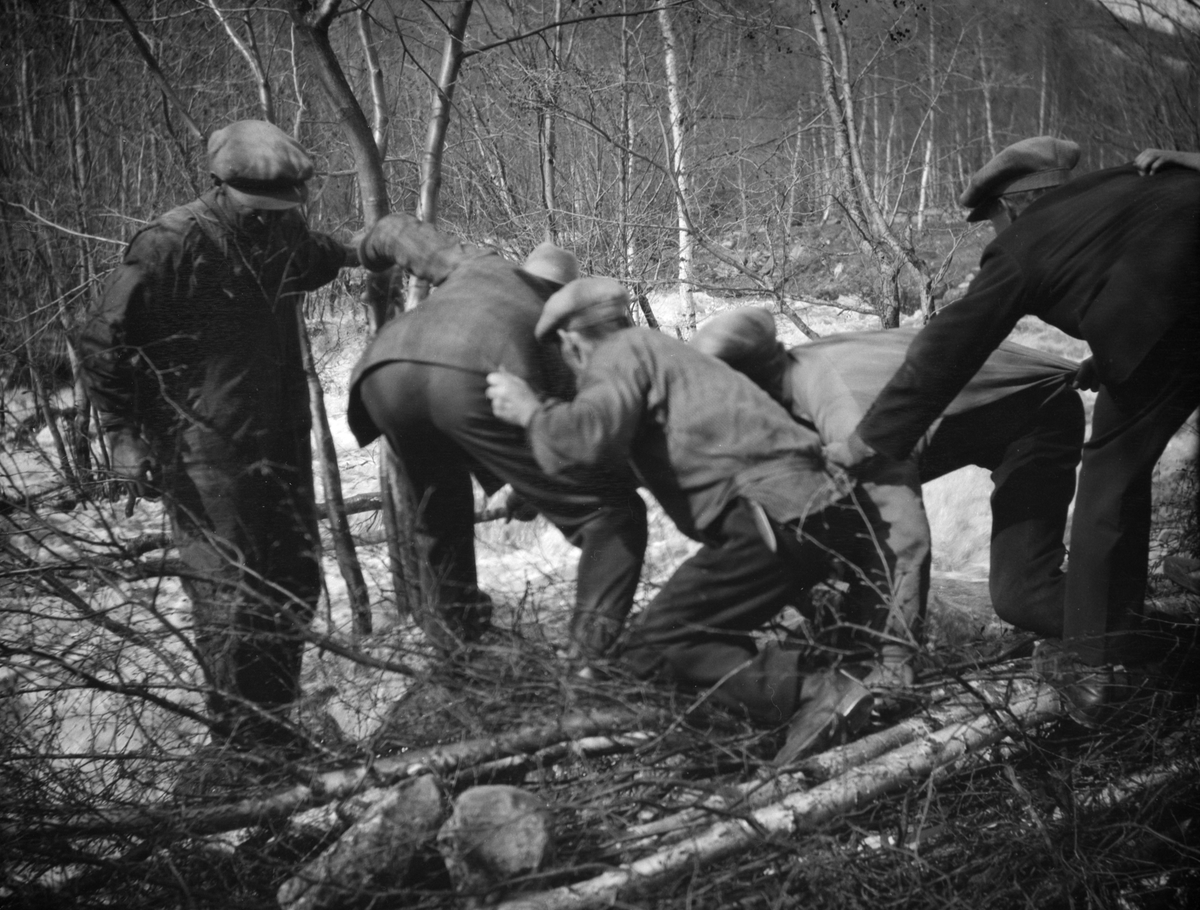 4 mannfolk i jobb mot vannmassenen ved Veikleåa, Kvam under flommen først i mai 1934.
