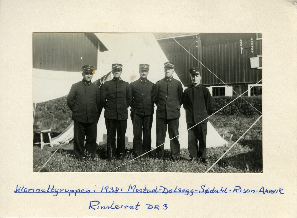 Gruppebilde av klarinettgruppen tatt ved Rinnleiret DR3 militærleir i 1938.
Gruppen står utenfor et såkalt "papegøyetelt". 

Avbildet: Mostad, Dalsegg, Dødahl, Rison og Aarvik.