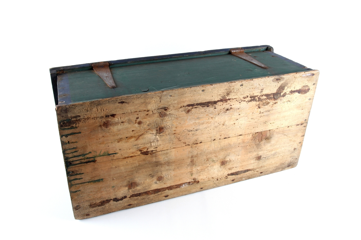 Grønnmalt trekiste med hjerteformet låsbeslag skåret ut i tre. Lås og hengsler i metall. Kisten har leddik med lokk innvendig.