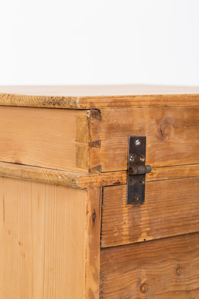 Toalettbord i ubehandlet tre. Det er rom for vaskebolle og skap under. Messingknott på døra til åpning og lukking, spor på innersiden av skapet kan tyde på at det tidligere også har vært en lås.